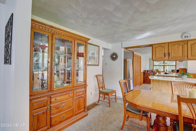 dining area featuring light carpet