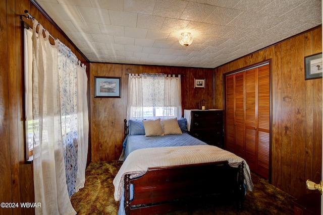 bedroom featuring carpet flooring, wooden walls, and a closet