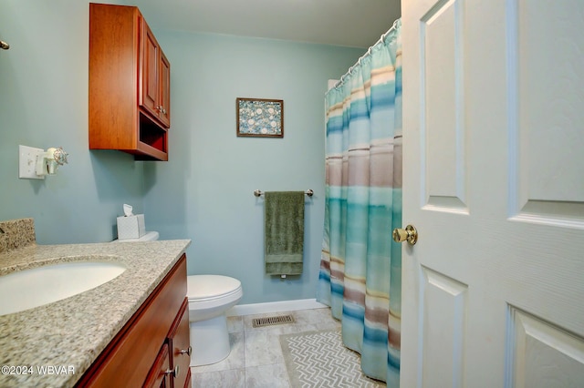 bathroom featuring tile patterned flooring, vanity, and toilet