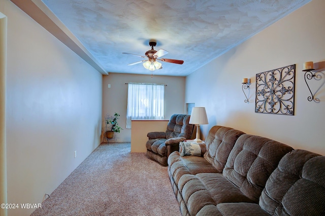 carpeted living room featuring ceiling fan and a textured ceiling