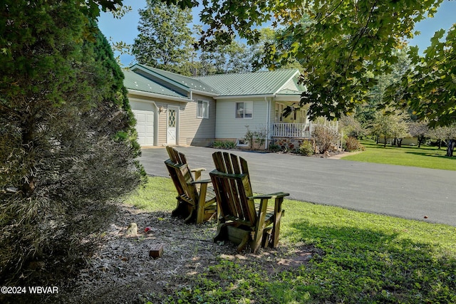 view of side of property with covered porch and a lawn