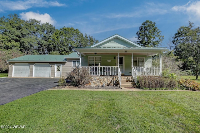 view of front of house featuring covered porch, a garage, and a front lawn