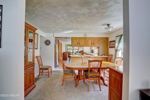 dining space featuring light carpet and a wealth of natural light