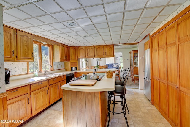 kitchen with a center island, a kitchen bar, sink, and appliances with stainless steel finishes