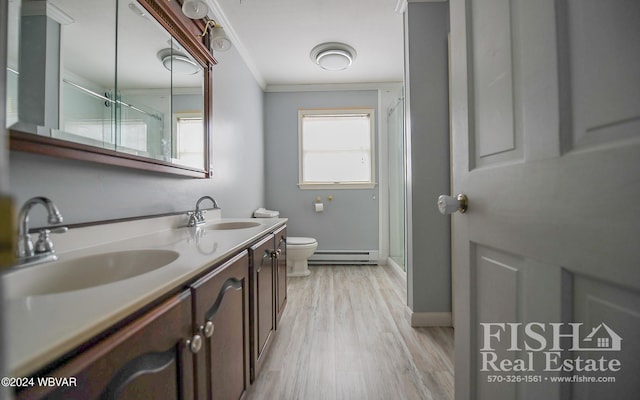 bathroom with a baseboard radiator, wood-type flooring, an enclosed shower, vanity, and ornamental molding