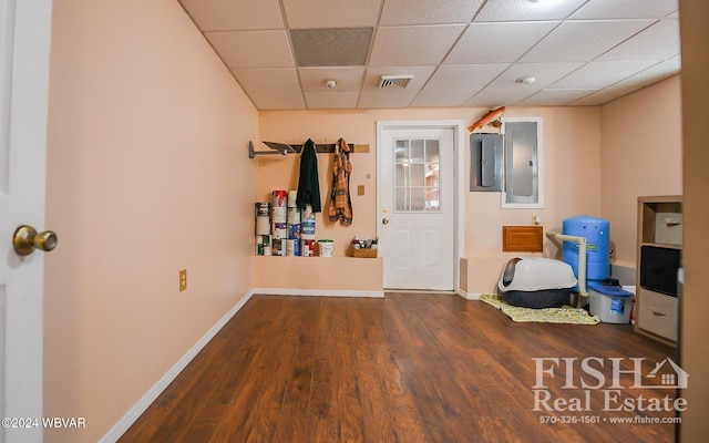 interior space featuring a drop ceiling, dark hardwood / wood-style flooring, and electric panel