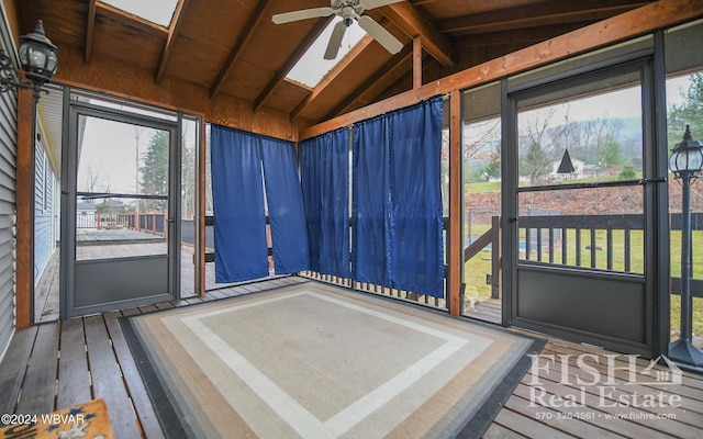 sunroom with ceiling fan, vaulted ceiling with skylight, and wood ceiling