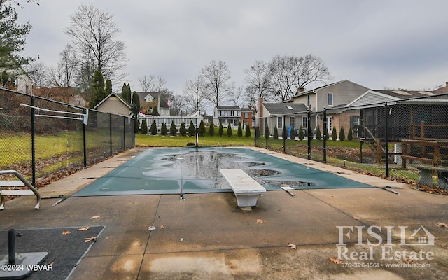 view of swimming pool with a diving board and a patio