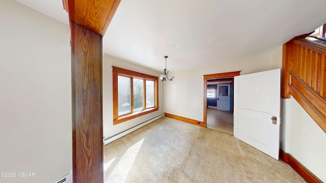 empty room featuring a baseboard heating unit and light colored carpet