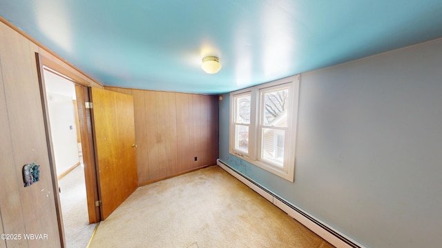 unfurnished room featuring a baseboard radiator and light colored carpet