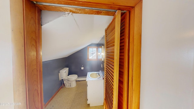 bathroom featuring vaulted ceiling, a baseboard heating unit, and toilet