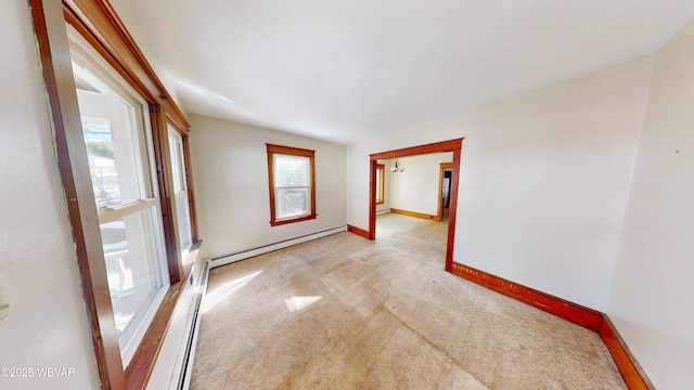 carpeted empty room with a baseboard heating unit