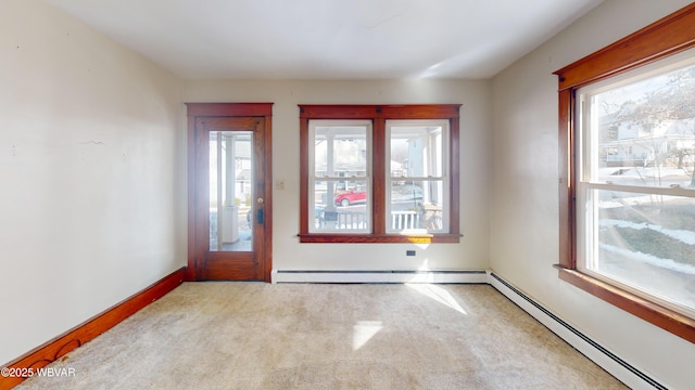 interior space featuring light colored carpet and a baseboard heating unit