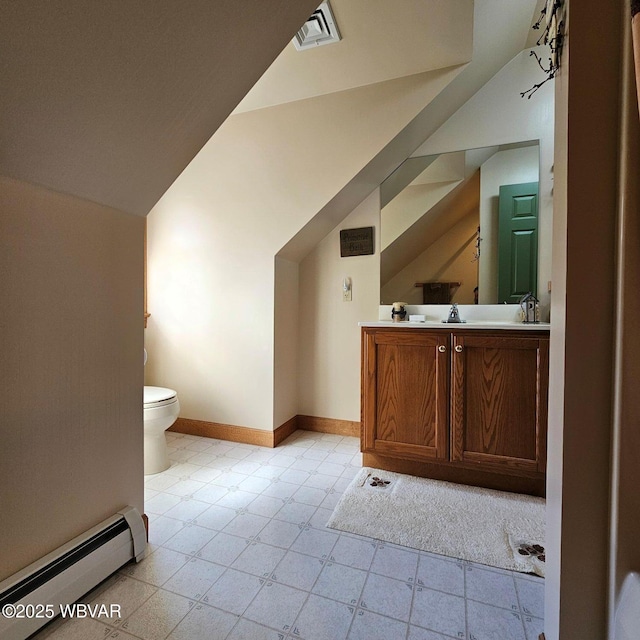 bathroom featuring a baseboard heating unit, vaulted ceiling, toilet, vanity, and tile patterned floors