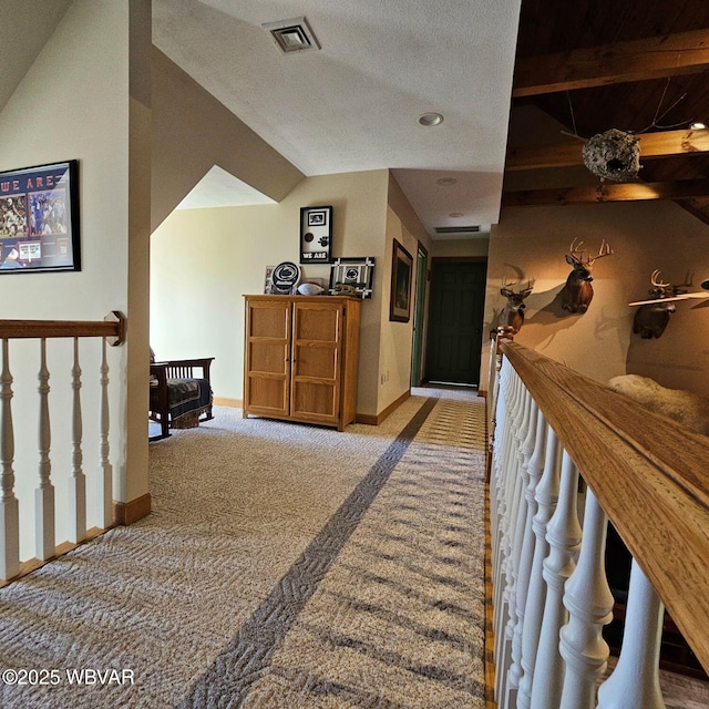 hallway with carpet flooring, baseboards, and an upstairs landing