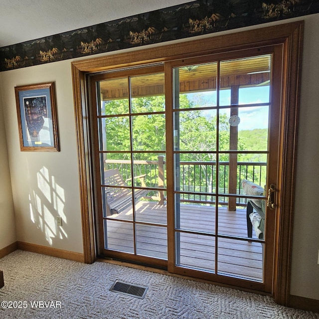 entryway featuring baseboards, healthy amount of natural light, and carpet