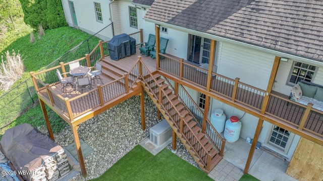 back of house featuring roof with shingles, a deck, stairs, outdoor dining area, and a patio area