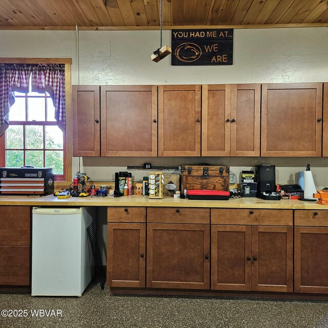 kitchen featuring wooden ceiling, fridge, and light countertops