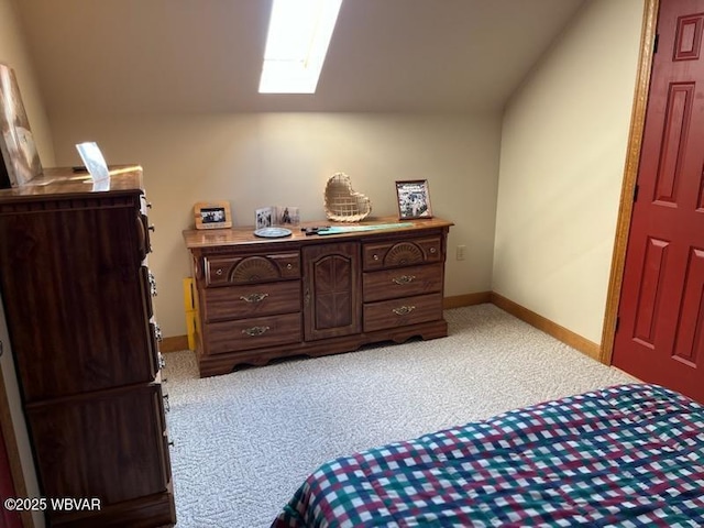 bedroom featuring light carpet, a skylight, and baseboards