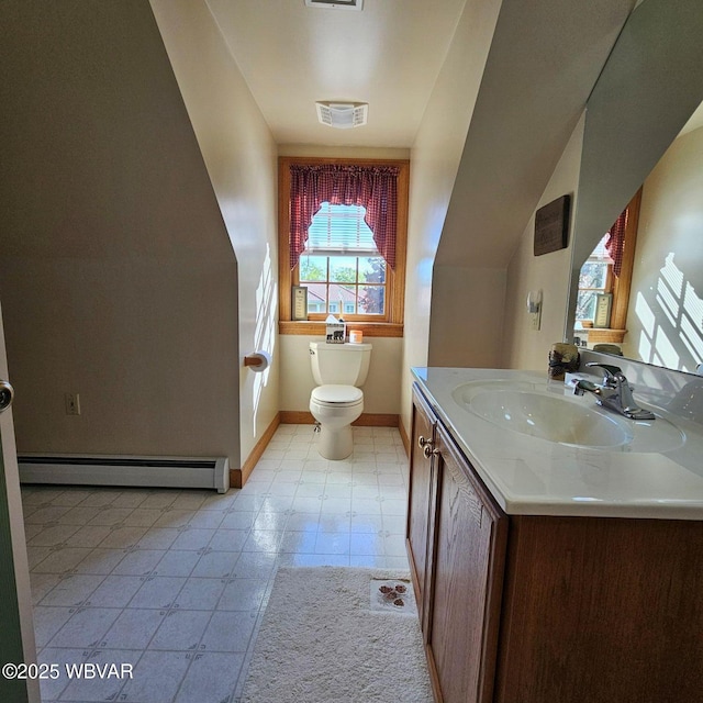 half bath with a baseboard heating unit, baseboards, toilet, vanity, and tile patterned floors
