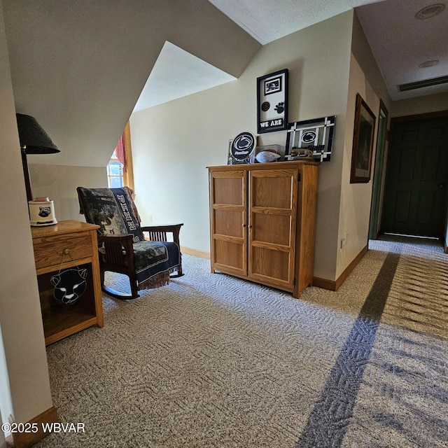 sitting room with carpet flooring, baseboards, and lofted ceiling