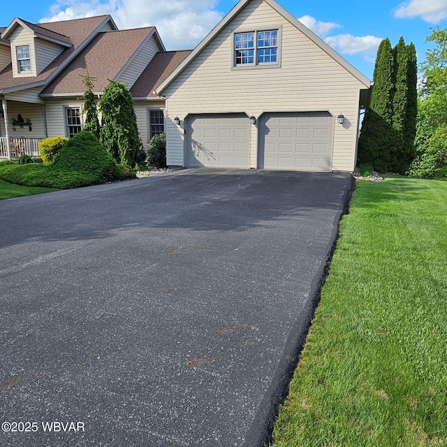 view of front of home with asphalt driveway, a garage, and a front yard
