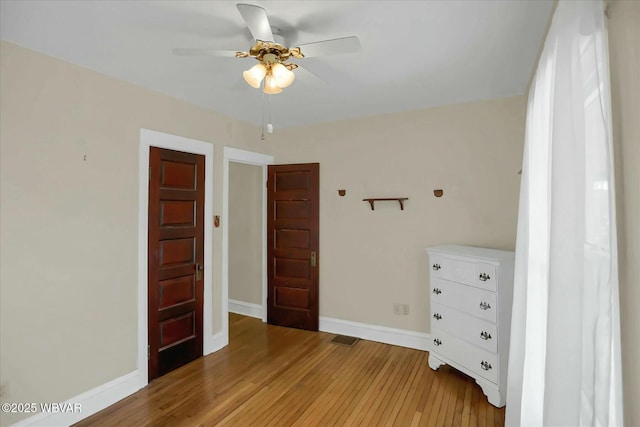 unfurnished bedroom with a ceiling fan, baseboards, and light wood-type flooring