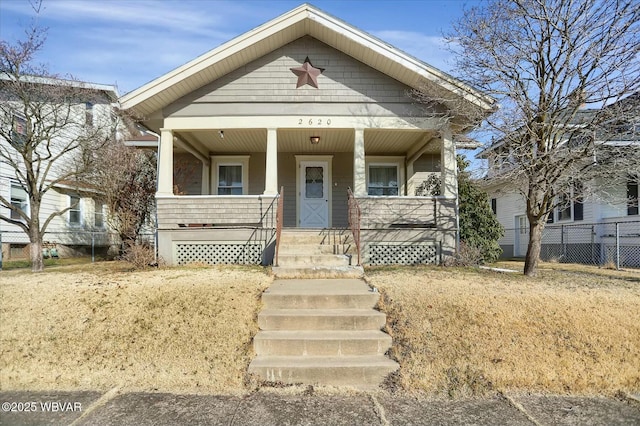 view of front of home featuring fence and covered porch