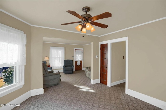 interior space featuring baseboards, carpet floors, ornamental molding, and a ceiling fan