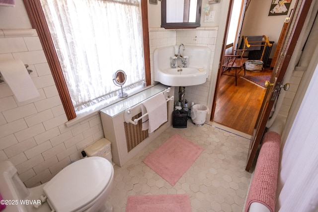 bathroom with tile walls, sink, and toilet