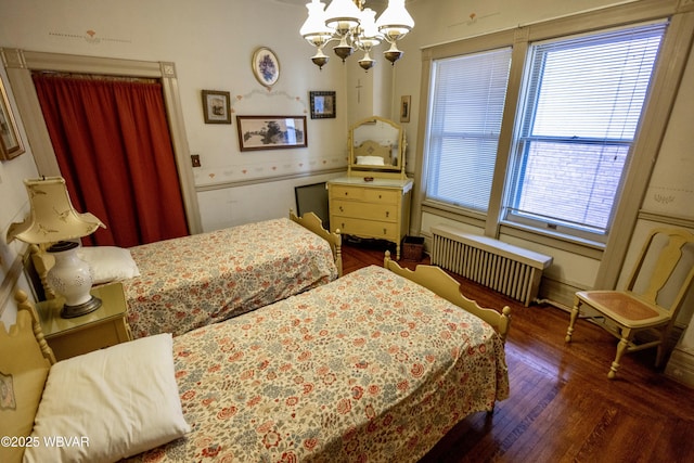 bedroom with radiator, a chandelier, and dark hardwood / wood-style flooring