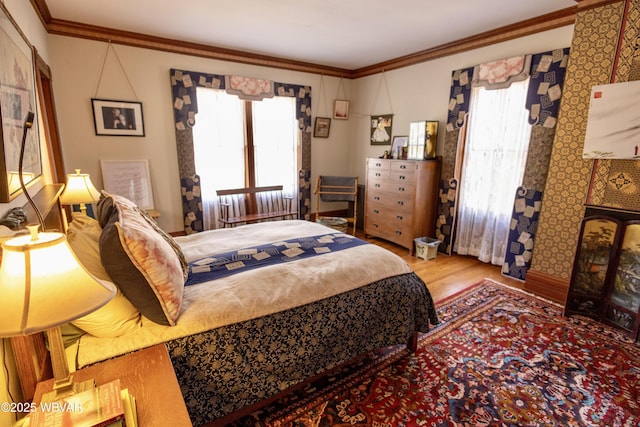 bedroom with multiple windows, crown molding, and light wood-type flooring