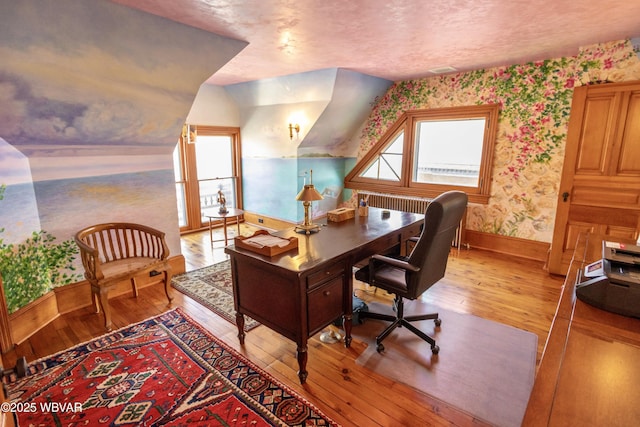 office area with a textured ceiling and light hardwood / wood-style flooring