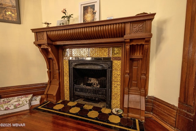 details featuring hardwood / wood-style flooring and a tiled fireplace