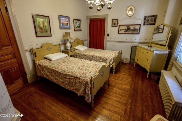 bedroom with dark hardwood / wood-style floors and a notable chandelier