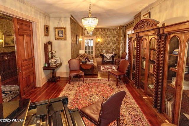 sitting room featuring crown molding, dark wood-type flooring, and a chandelier