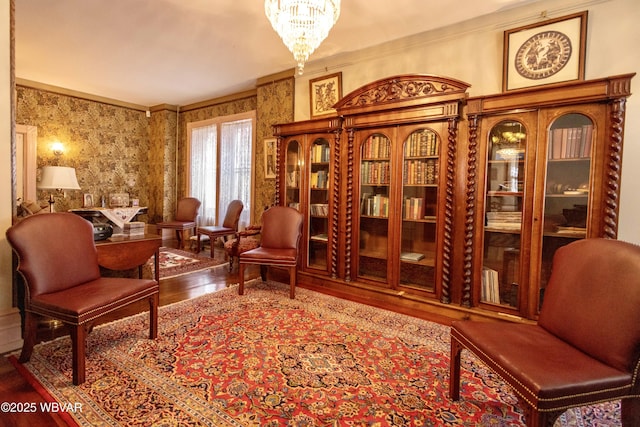 living area with crown molding, a chandelier, and hardwood / wood-style floors