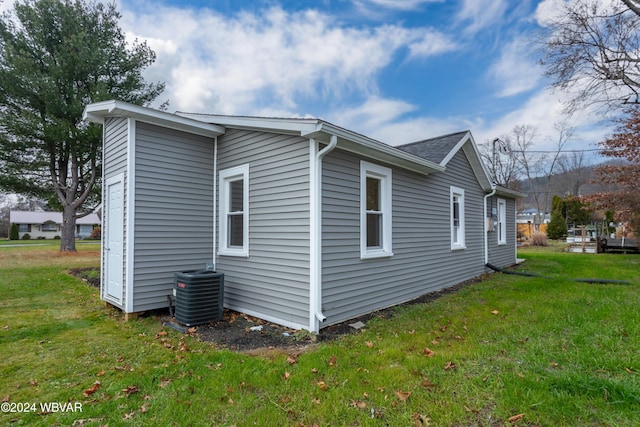 view of home's exterior featuring central air condition unit and a lawn