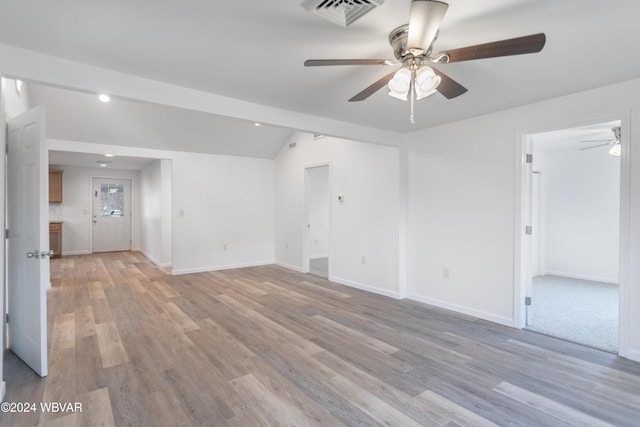 spare room with light wood-type flooring, ceiling fan, and lofted ceiling