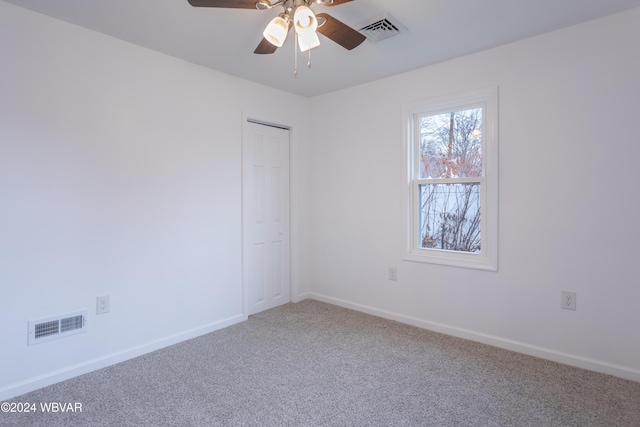 spare room featuring ceiling fan and carpet