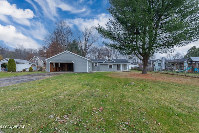 single story home featuring a front yard, a garage, and an outdoor structure