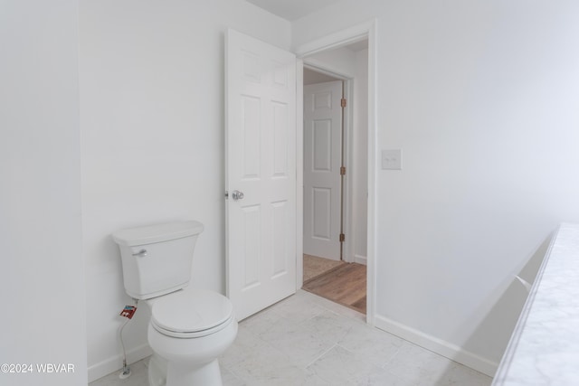 bathroom with hardwood / wood-style floors and toilet