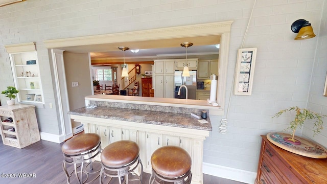 524 Pardee Rd, Millmont, PA 17845 - kitchen with stainless steel fridge, a kitchen breakfast bar, a peninsula, decorative light fixtures, and dark wood-style floors