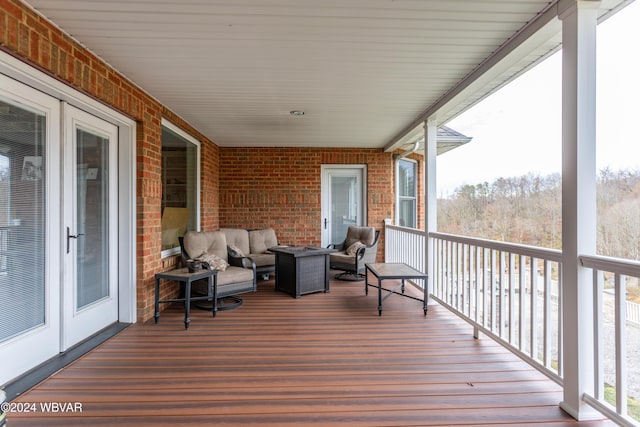 wooden terrace with an outdoor living space