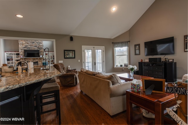 living room featuring french doors, a fireplace, lofted ceiling, and dark hardwood / wood-style floors