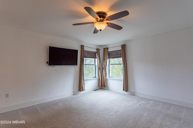 spare room with ceiling fan and light carpet