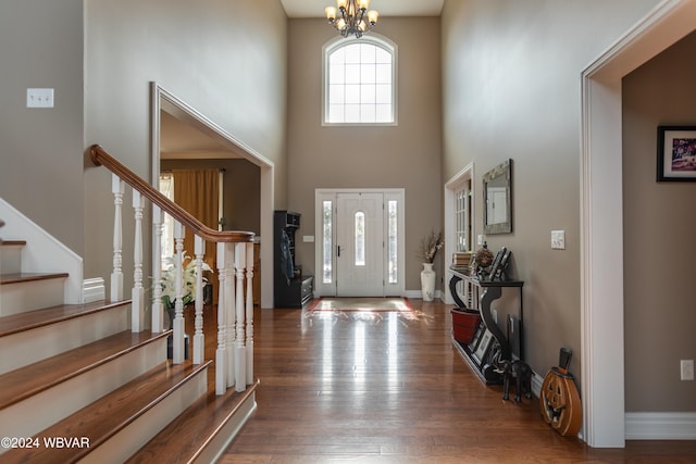 foyer with a notable chandelier, dark hardwood / wood-style floors, and a high ceiling