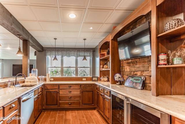 kitchen featuring pendant lighting, sink, stainless steel dishwasher, and light stone countertops