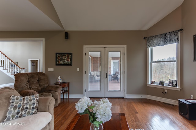 living room featuring hardwood / wood-style flooring, vaulted ceiling, and french doors