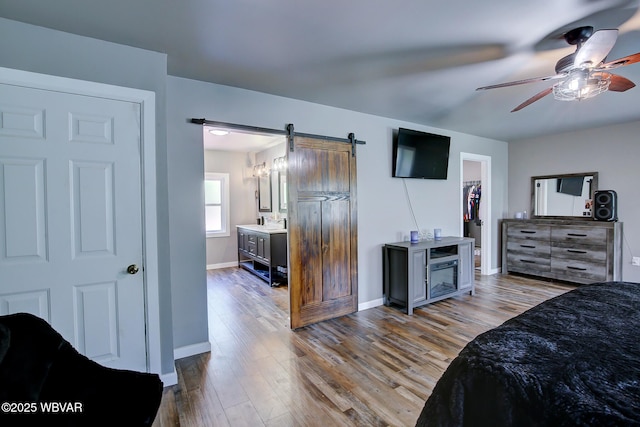 260 Selkirk Rd, Williamsport, PA 17701 - bedroom featuring a barn door, baseboards, wood finished floors, and a spacious closet